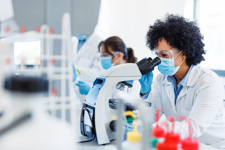 Photo shows a scientist using a microscope in a laboratory/Getty Images