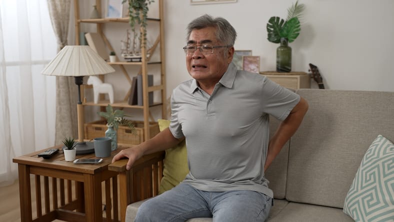 Older man clutching lower back in pain