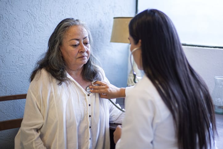 Doctor in medical examination to older woman