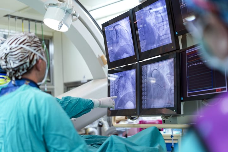 Surgeon explaining medical video feed to colleague during surgery