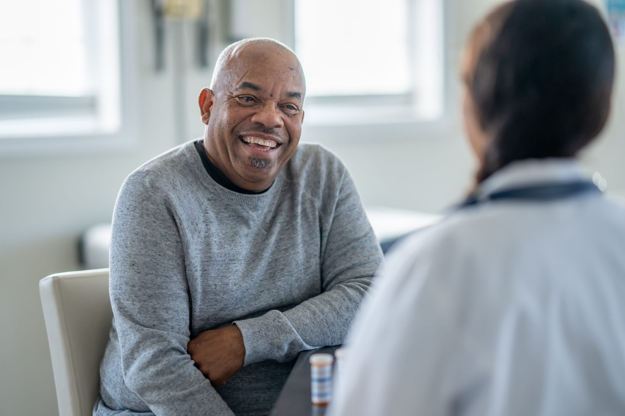 A senior gentleman of African decent meets with his doctor as they review his medications together.