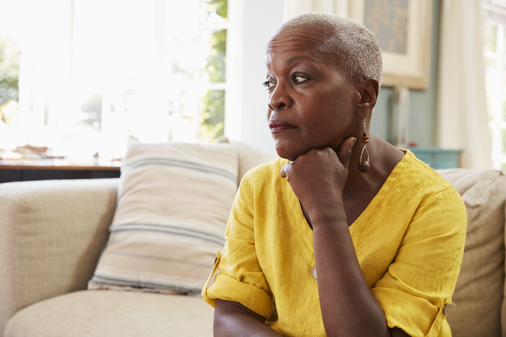 Older sad woman resting chin on hand