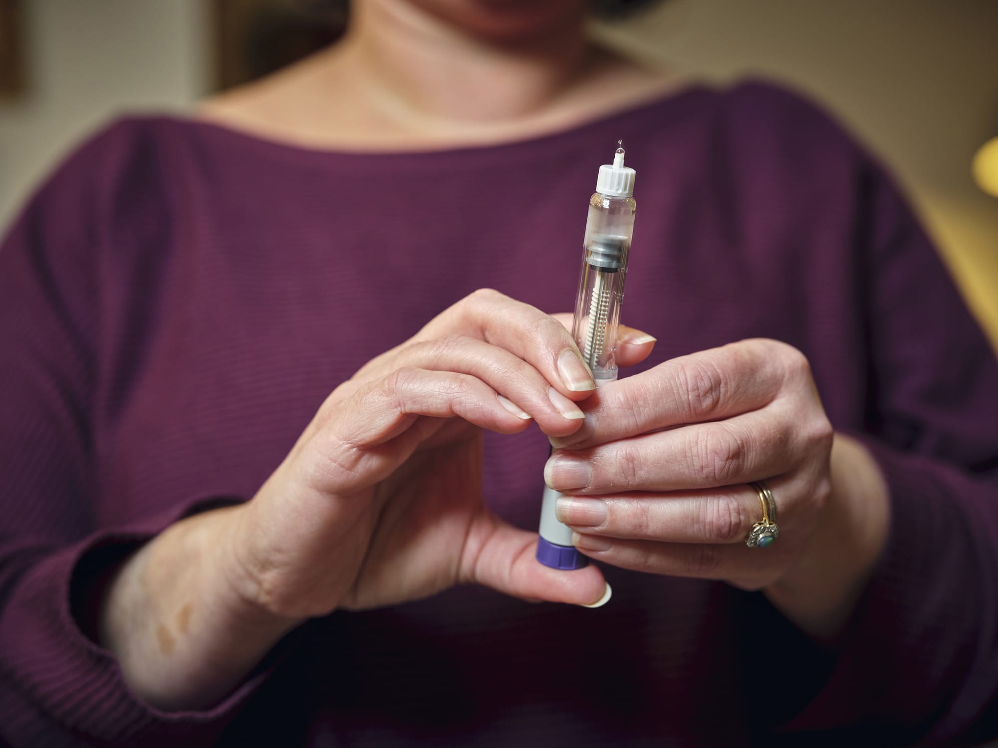 A woman prepares for a subcutaneous self-injection with a semaglutide pen