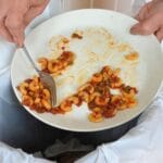 Scraping pasta from plate to garbage